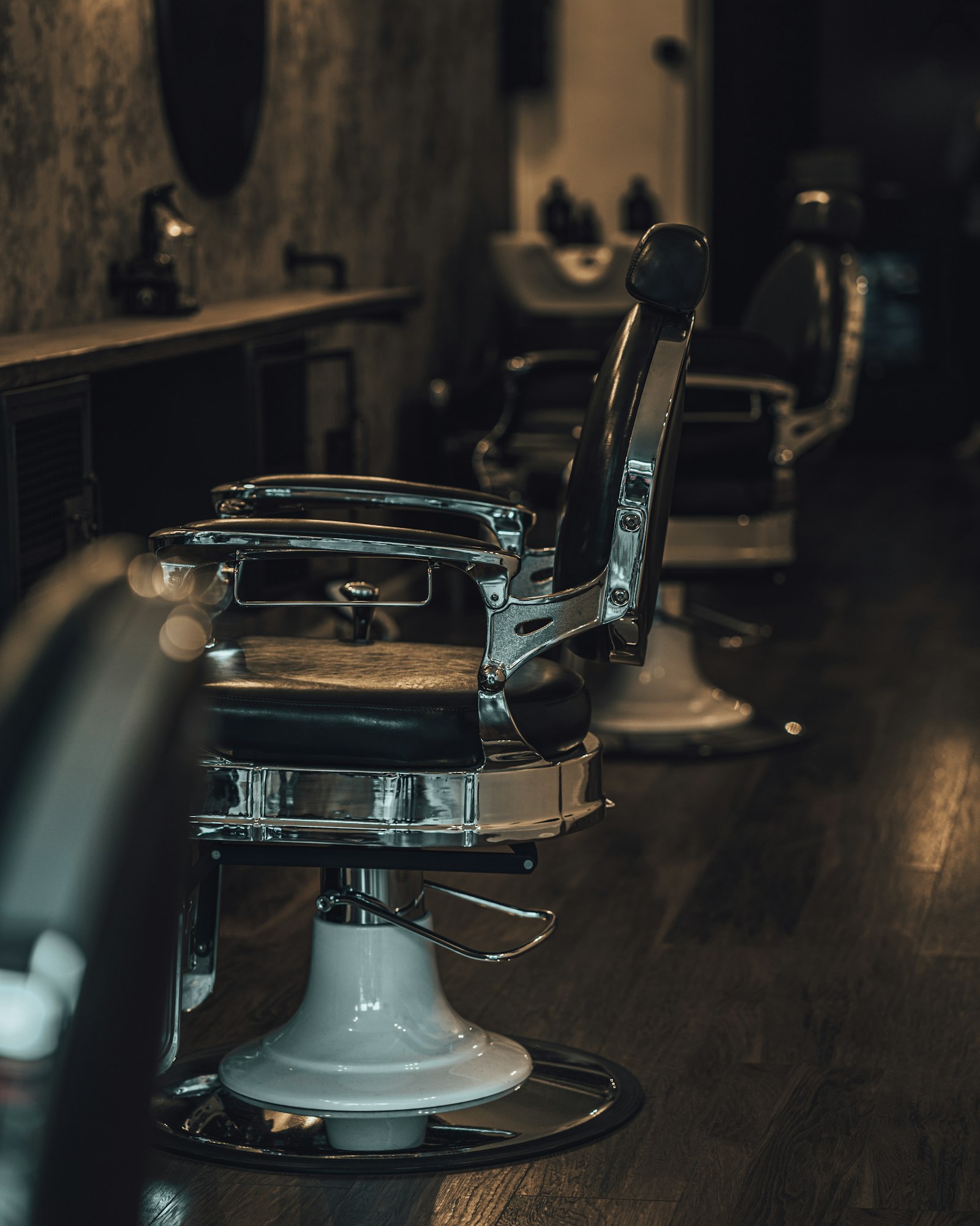 Chrome and leather barber chair in low light