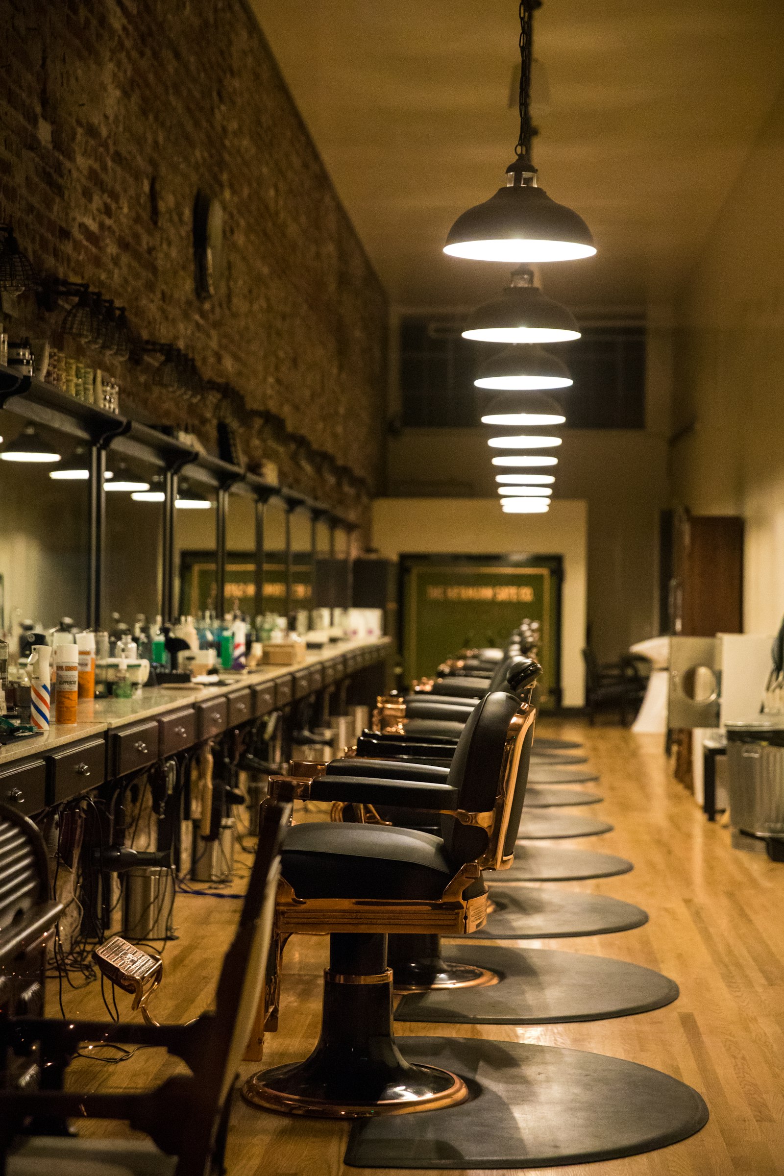 Row of vintage barber chairs under pendant lamps