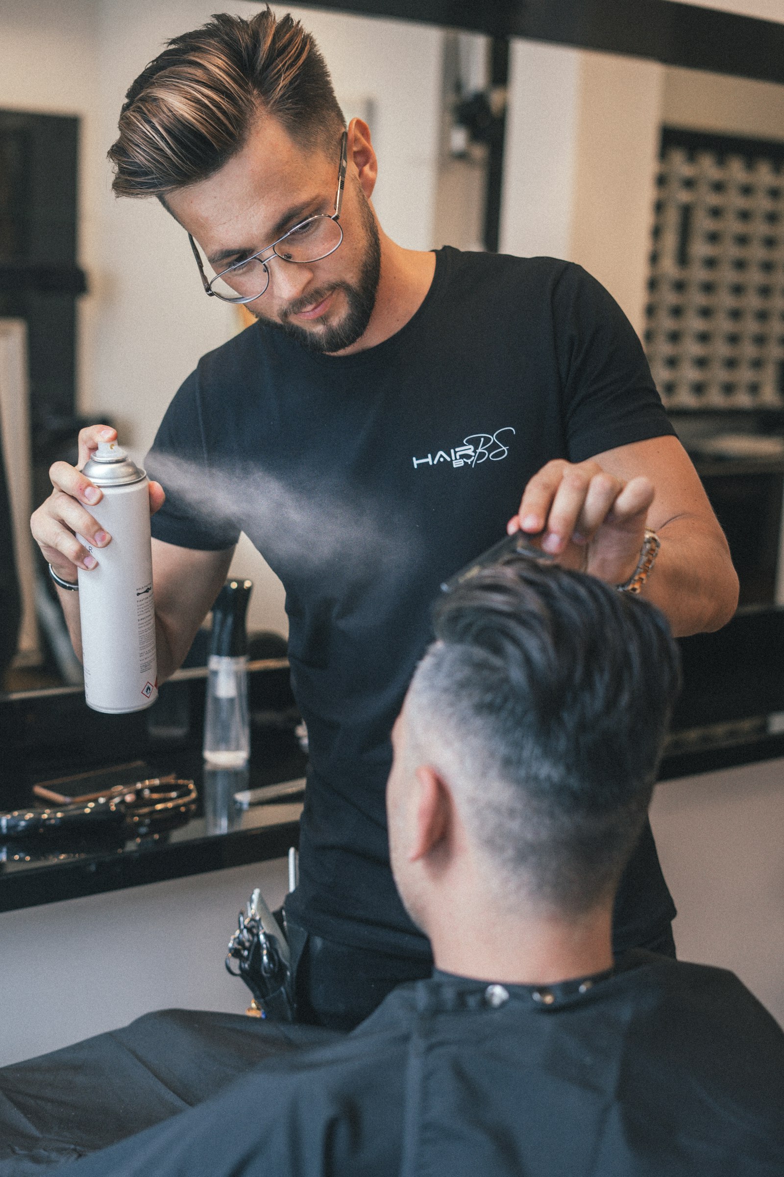 Marco Reyes finishing a cut with spray and comb